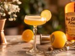 Bee's Knees Cocktail mit Zitronenscheibe und Honigdekor auf eleganter Bartheke