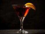 SEO-optimierter Alt-Text: Americano Cocktail mit Gin in einem eleganten Glas, garniert mit einer Orangenscheibe
