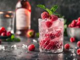 Raspberry Gin mit was mischen, leckere Cocktailzutaten und frische Himbeeren auf einem Holztisch