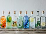 Gin Test die besten 10: Auswahl an hochwertigen Gin-Flaschen auf Holztisch arrangiert